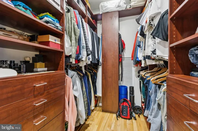 a view of walk in closet with clothes and shoes