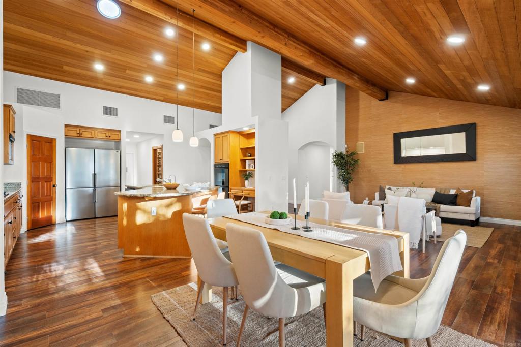 1062 Monterey Vista Way Encinitas, CA 92024 - Photo 22 of 70 a dining hall with stainless steel appliances a dining table and chairs with wooden floor