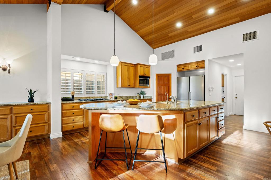 1062 Monterey Vista Way Encinitas, CA 92024 - Photo 26 of 70 a large kitchen with kitchen island granite countertop lots of white cabinets appliances and furniture