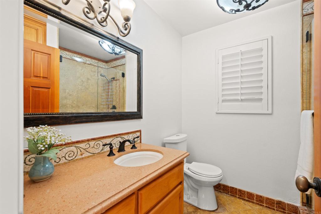 1062 Monterey Vista Way Encinitas, CA 92024 - Photo 40 of 70 a bathroom with a toilet a sink and mirror