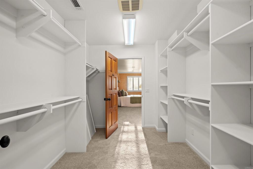 1062 Monterey Vista Way Encinitas, CA 92024 - Photo 54 of 70 a view of walk in closet with window and hardwood floor
