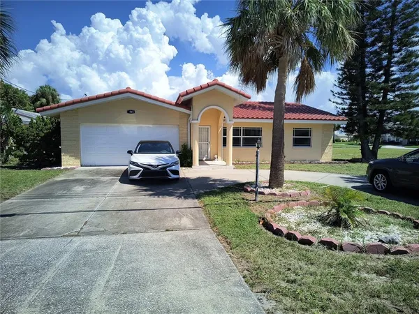 a front view of a house with a garden and trees