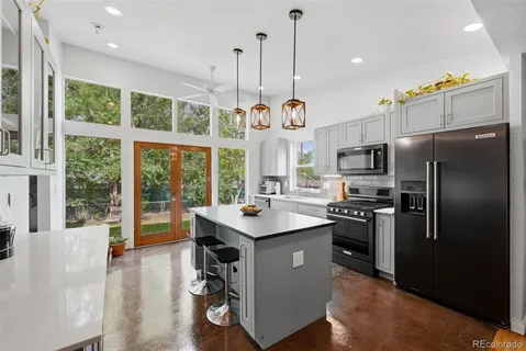 a kitchen with stainless steel appliances granite countertop a sink a stove and a refrigerator