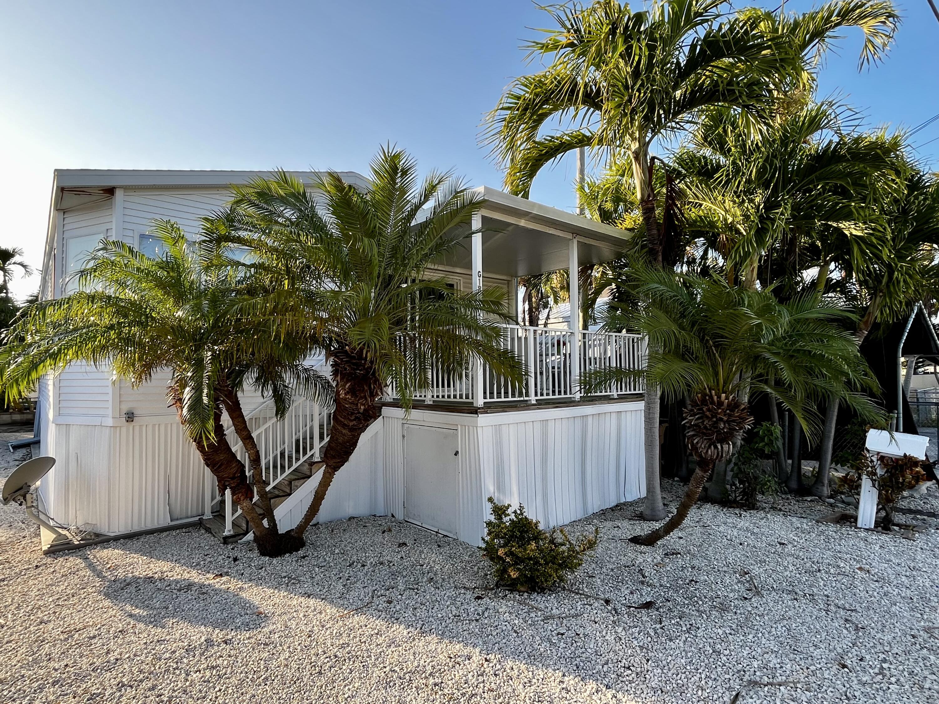 a front view of a house with a tree