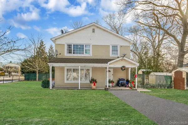 a group of people sitting in front of a house with a yard