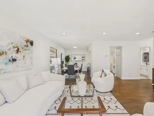 a living room with furniture a rug and white walls