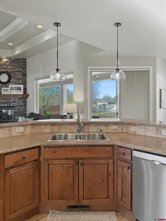 a kitchen with stainless steel appliances granite countertop a sink a stove and a wooden floors