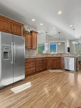 a large kitchen with stainless steel appliances kitchen island granite countertop a refrigerator and a stove top oven