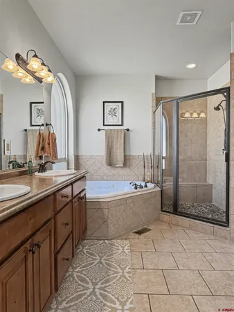 a spacious bathroom with a granite countertop sink a toilet a mirror and bathtub