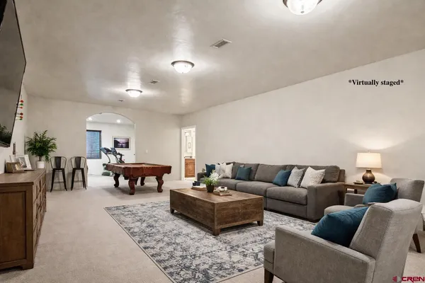 a living room with furniture and a dining table with wooden floor