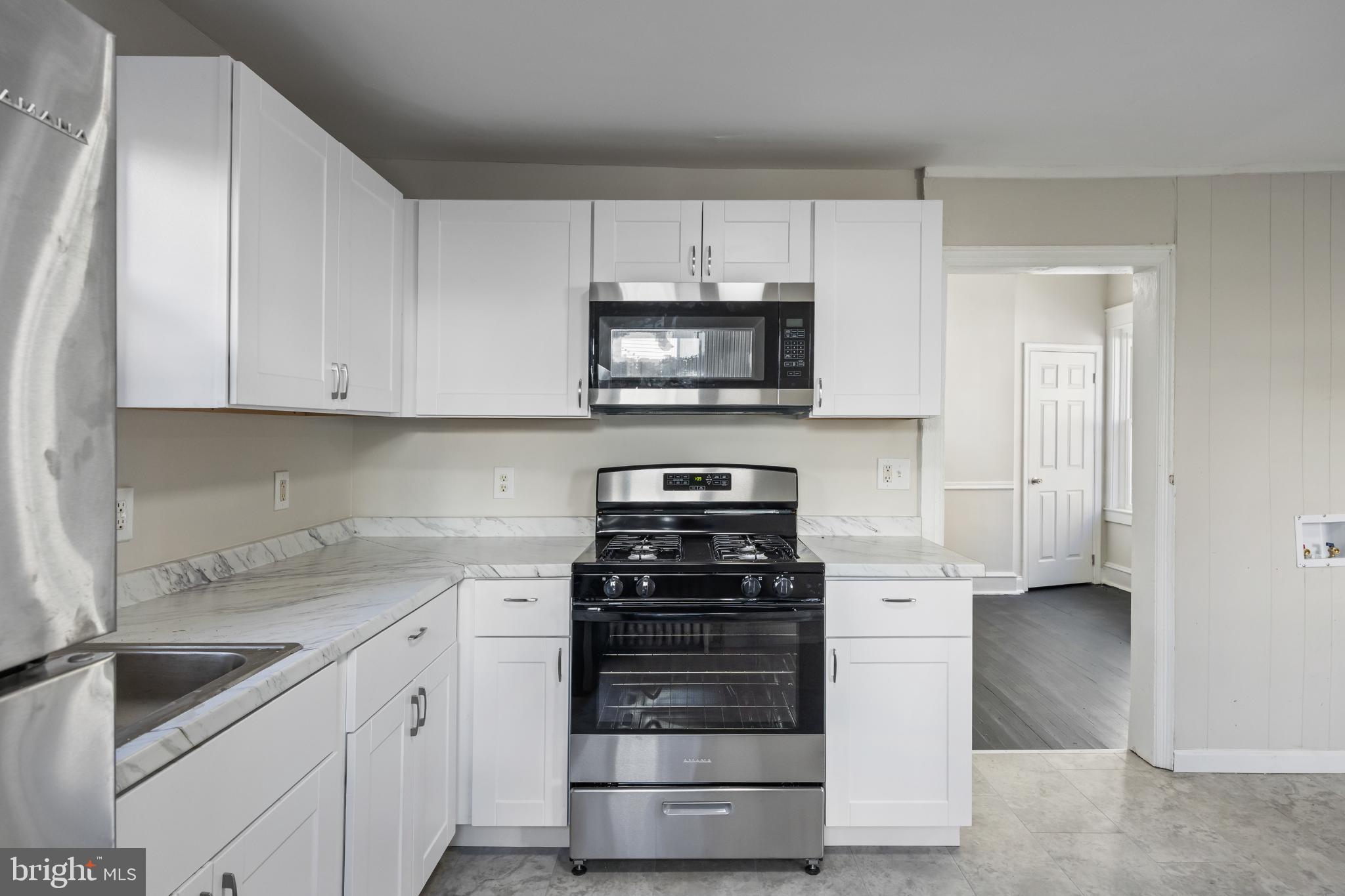 2003 Edgmont Avenue Chester, PA 19013 - Photo 21 of 40 a kitchen with granite countertop white cabinets and stainless steel appliances