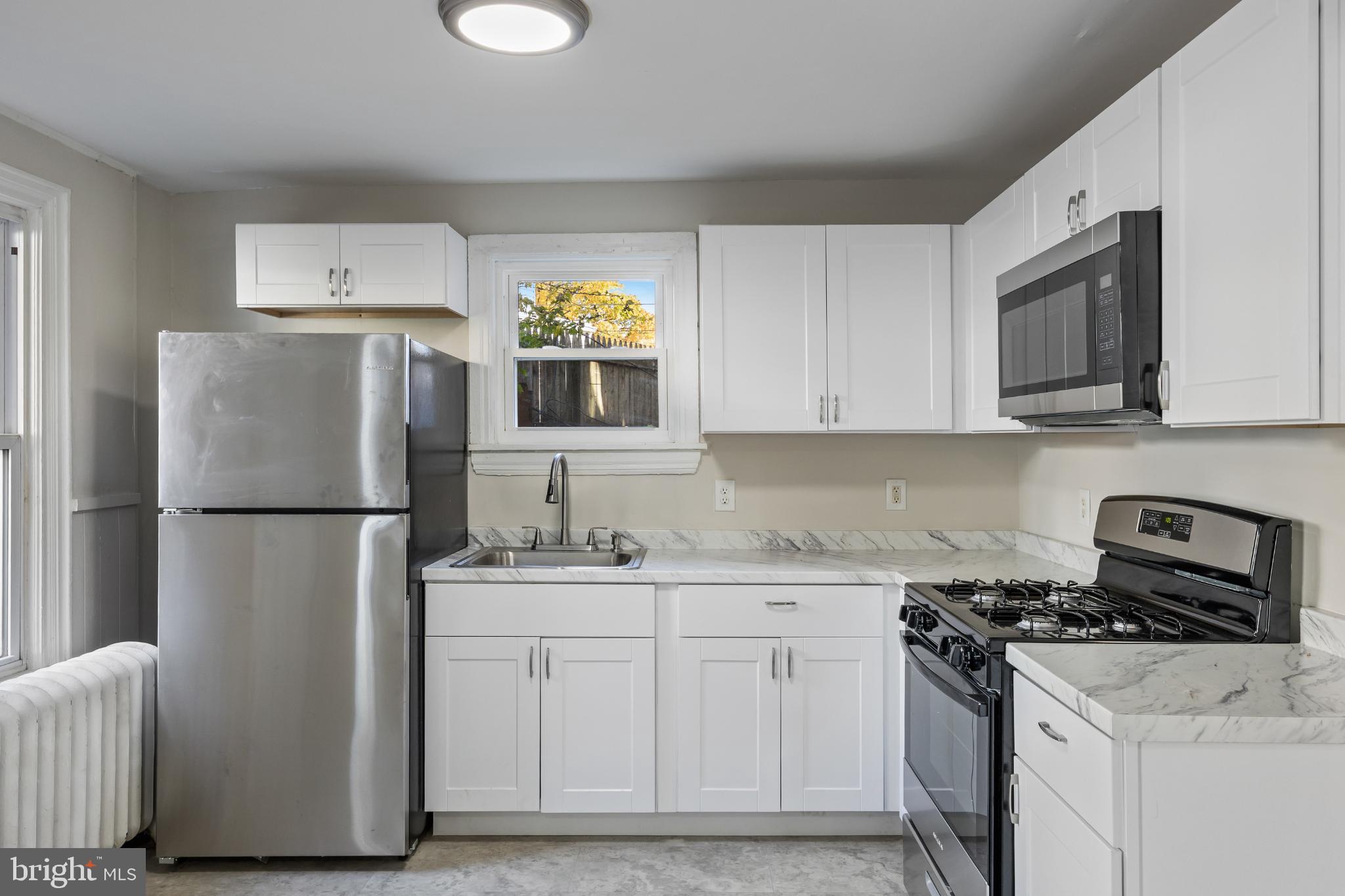 2003 Edgmont Avenue Chester, PA 19013 - Photo 22 of 40 a kitchen with stainless steel appliances a refrigerator stove and microwave