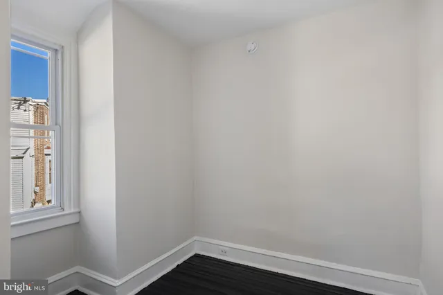 a view of a small space with wooden floor and a window