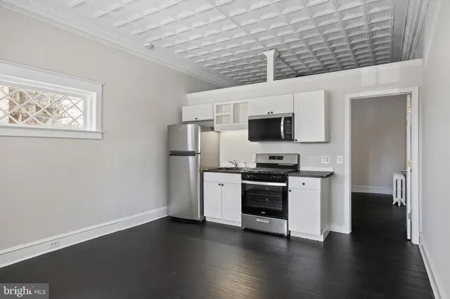 a kitchen with stainless steel appliances a stove top oven a sink and a microwave