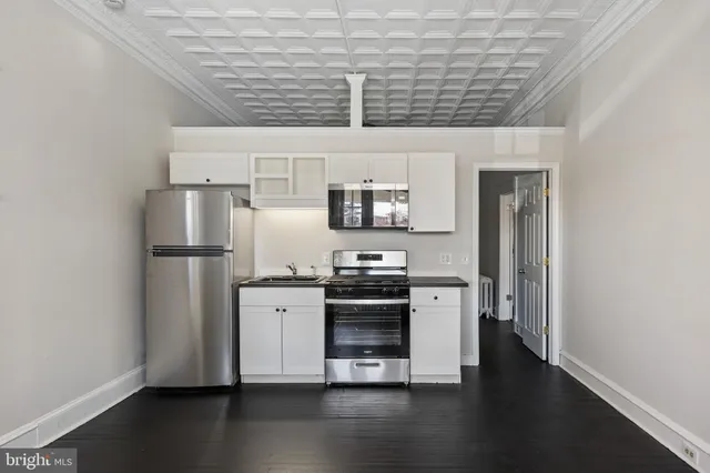 a kitchen with stainless steel appliances and wooden floor