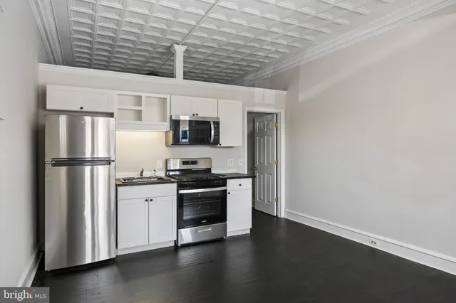 a kitchen with stainless steel appliances a refrigerator stove and microwave