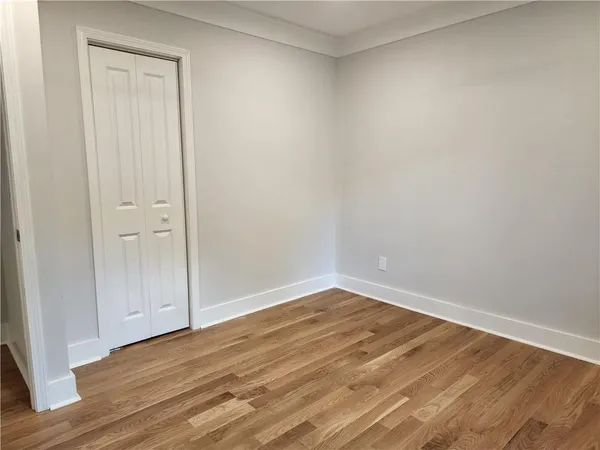 a view of an empty room with wooden floor