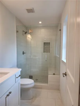 a bathroom with a toilet a sink and shower