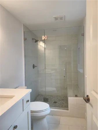 a bathroom with a shower a toilet and sink
