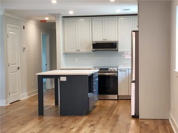 a kitchen with stainless steel appliances granite countertop a stove a refrigerator and a sink
