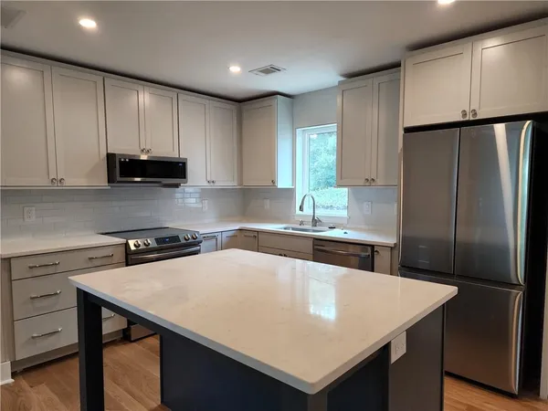 a kitchen with a refrigerator a sink a stove and cabinets
