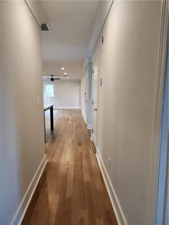 a view of a hallway with wooden floor