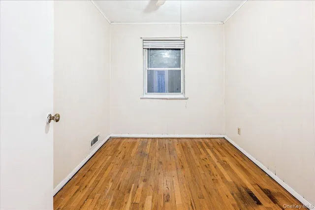 a view of a room with wooden floor and window