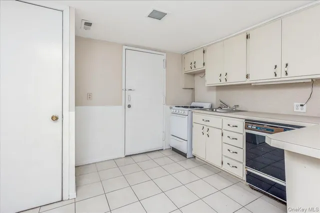 a kitchen with white cabinets and white appliances