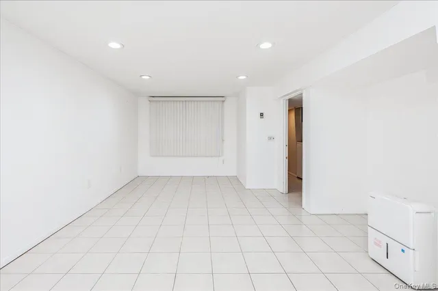 an empty room with white walls and tiles