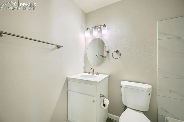 a bathroom with a sink mirror and toilet