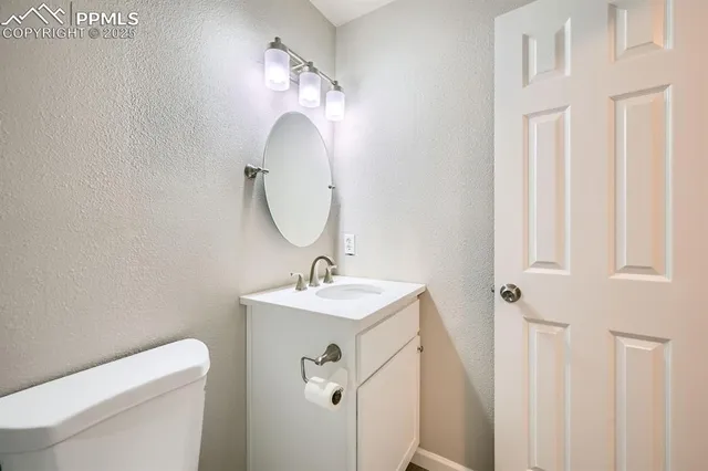 a bathroom with a toilet a sink and mirror