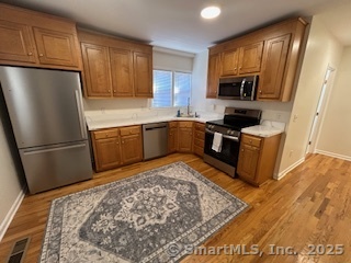 10 Hill Street, Unit 1 New Canaan, CT 06840 - Photo 3 of 10 a kitchen with stainless steel appliances granite countertop a refrigerator stove top oven and sink