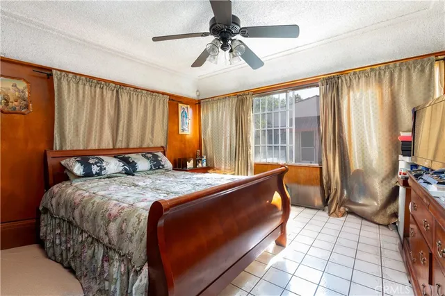 a bedroom with a bed and a chandelier fan
