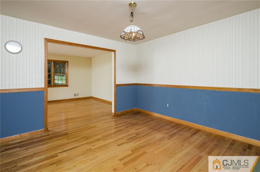 21 Station Road Cranbury, NJ 08512 - Photo 4 of 25 a view of an empty room with wooden floor and a window