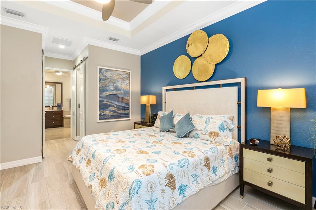 13628 Mandarin Circle Naples, FL 34109 - Photo 22 of 48 a bedroom with a bed and dresser with mirror