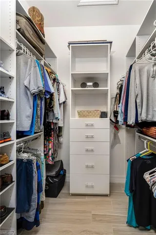 a view of walk in closet with clothes and shoes