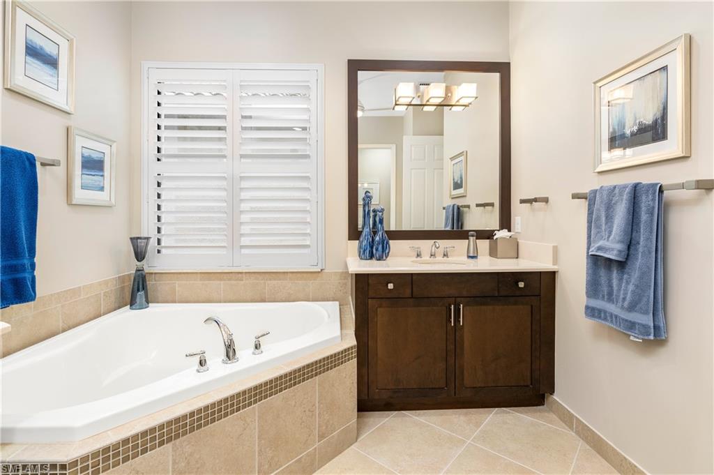 13628 Mandarin Circle Naples, FL 34109 - Photo 26 of 48 a bathroom with a bathtub sink and mirror