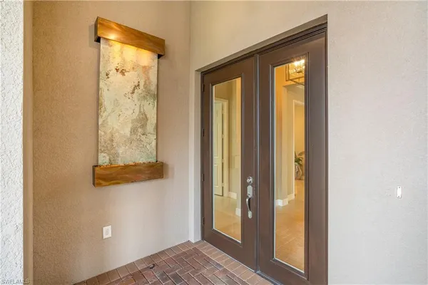 a view of a hallway with wooden floor and chandelier