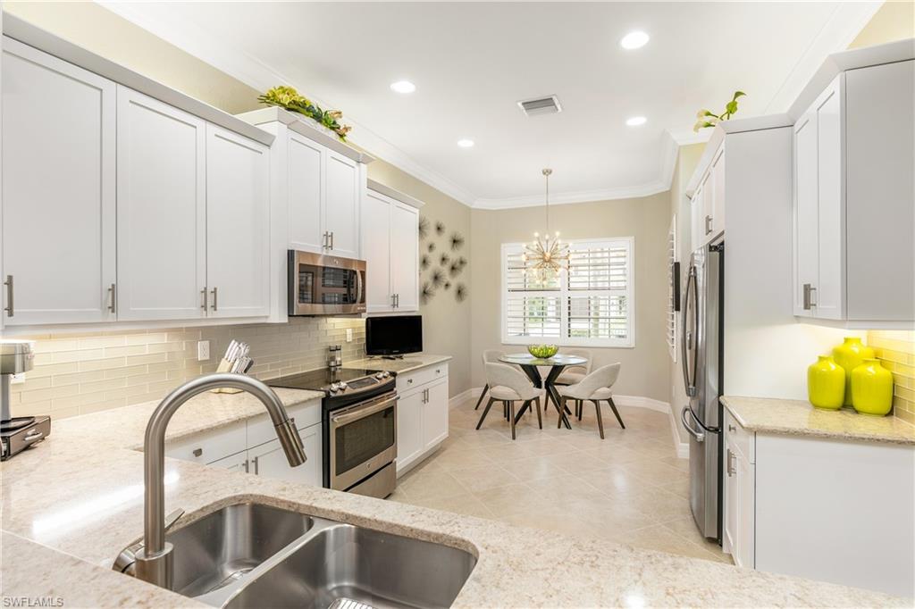 13628 Mandarin Circle Naples, FL 34109 - Photo 7 of 48 a kitchen with table and chairs