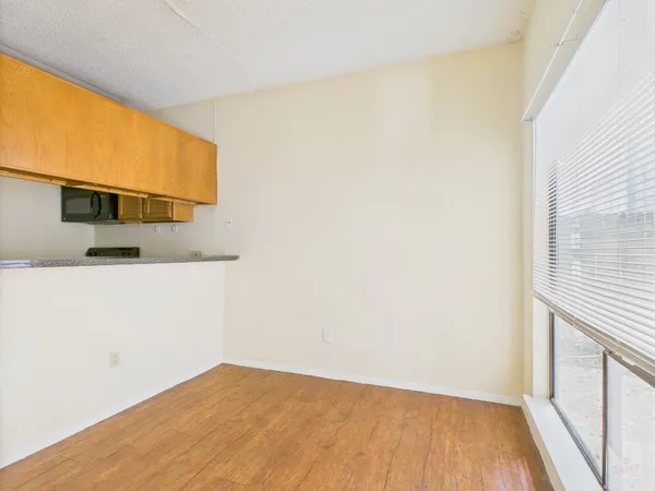 a view of a room with wooden floor and a window