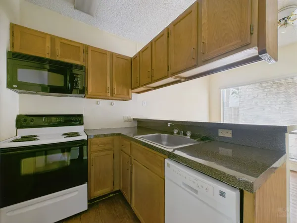 a kitchen with granite countertop a sink and a stove top oven