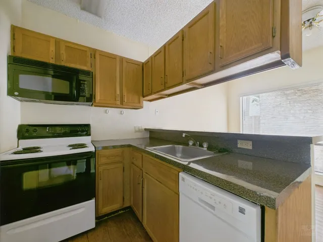 a kitchen with granite countertop a sink and a stove top oven