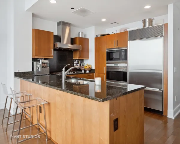 a kitchen with stainless steel appliances a sink a stove a microwave a sink and a refrigerator