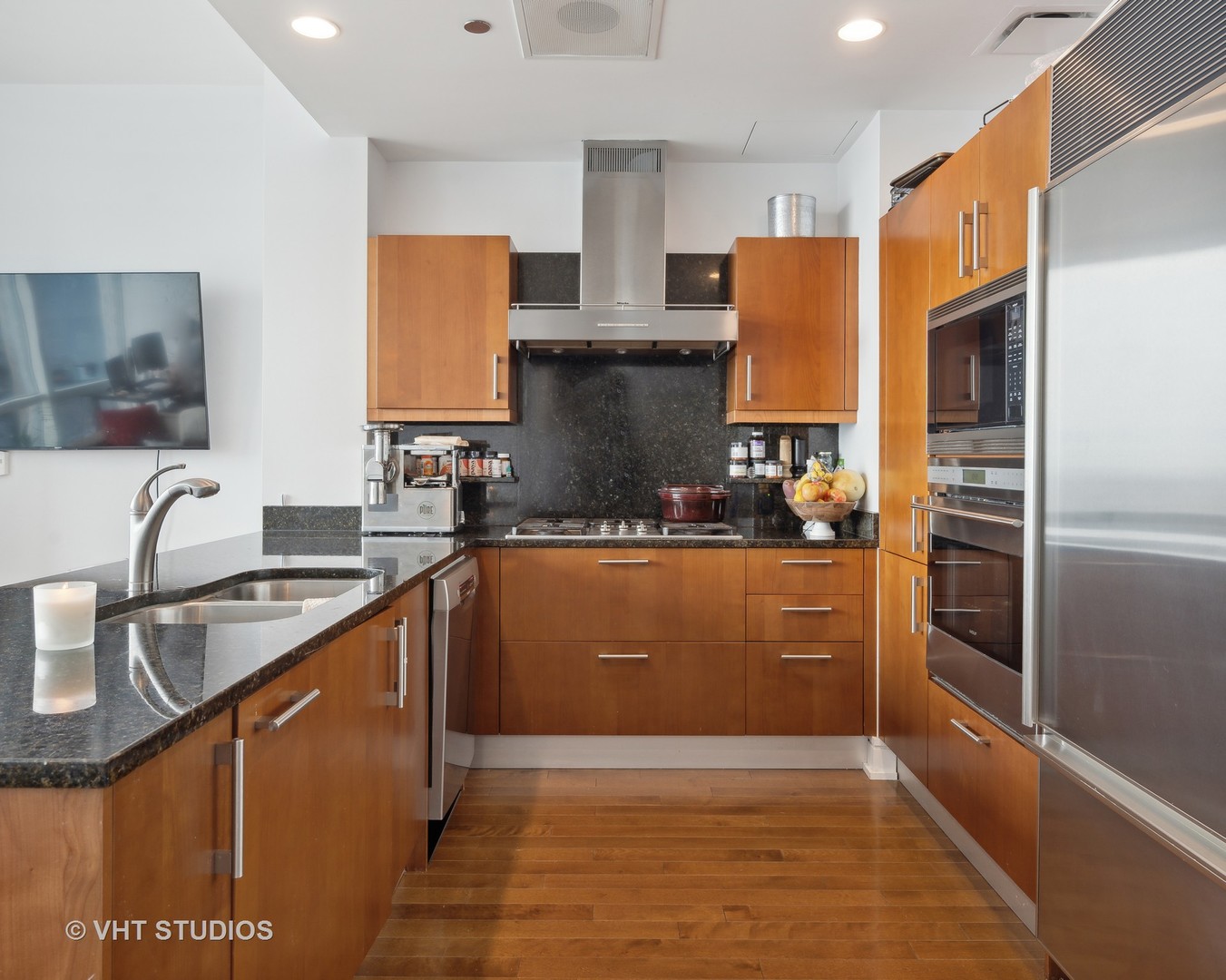 401 North Wabash Avenue, Unit 30E Chicago, IL 60611 - Photo 5 of 13 a kitchen with stainless steel appliances granite countertop a refrigerator a sink dishwasher a stove with wooden cabinets