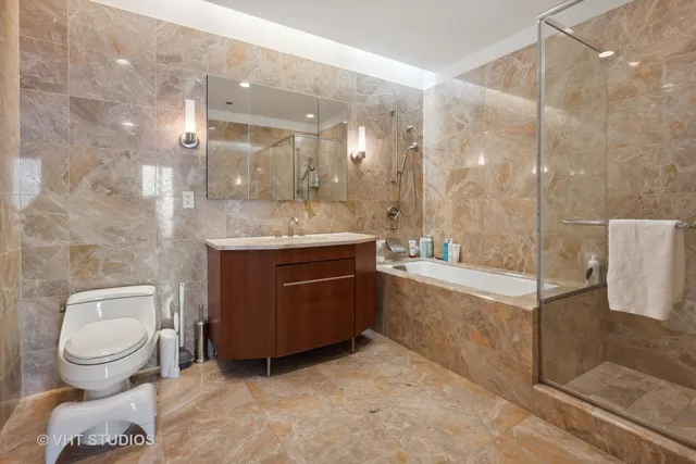 a bathroom with a granite countertop sink a toilet and bathtub