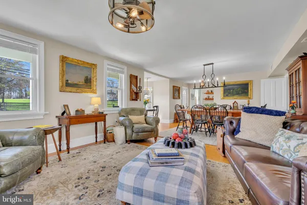 a kitchen with stainless steel appliances granite countertop a refrigerator a sink dishwasher a stove and white countertops with wooden floor