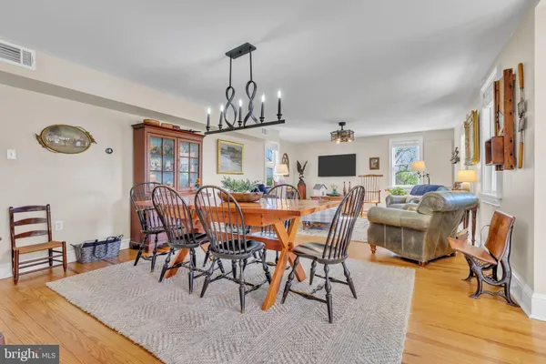 a view of a dining room and livingroom with furniture wooden floor a chandelier
