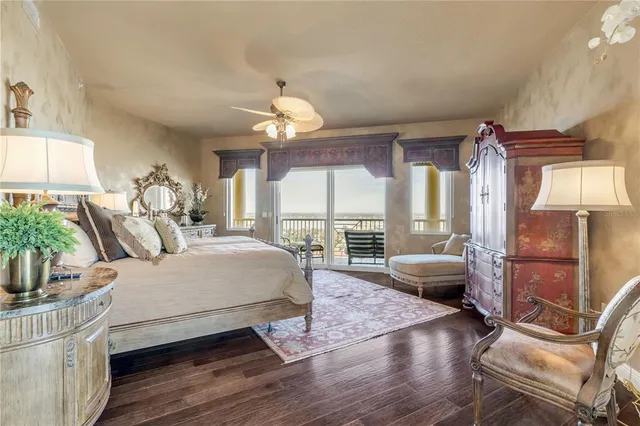 a bedroom with a bed and large windows