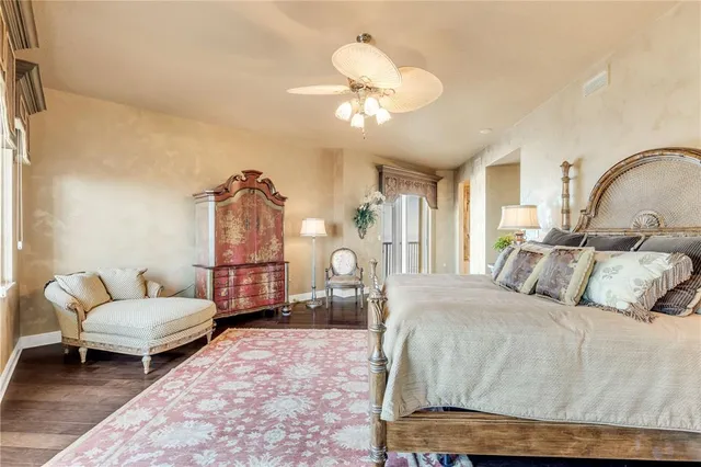 a view of a hallway with wooden floor and a bathroom