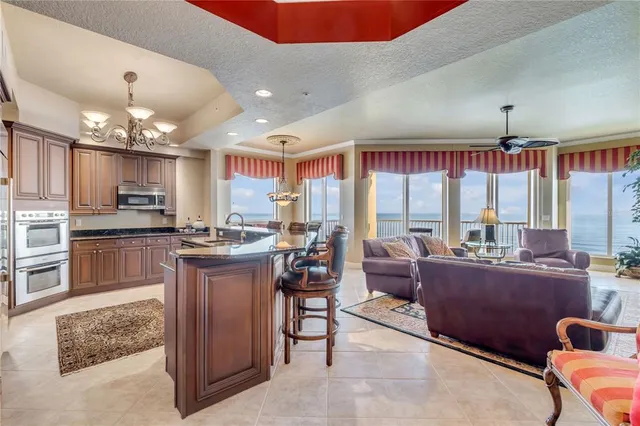 a dining room with furniture a chandelier and kitchen view